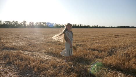 serious sad girl a child stands on a wheat mown field