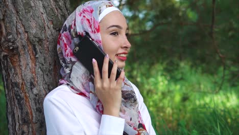 young woman talking on phone in a forest