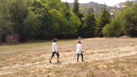 a blind woman walks with a cane through a natural area with a guide helping her explore the wilderness 8