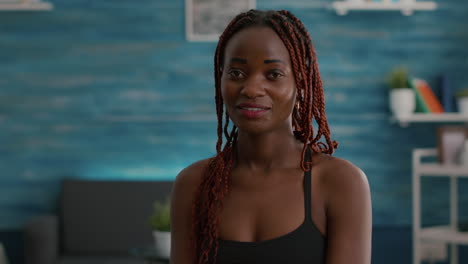 Portrait-of-athlete-with-black-skin-looking-into-camera-while-siting-on-aerobics-ball