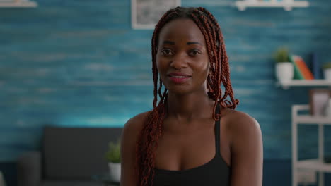 portrait of athlete with black skin looking into camera while siting on aerobics ball