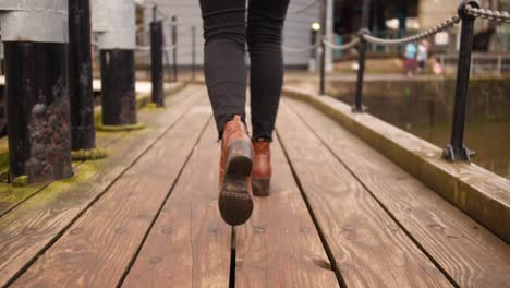 shot of woman leg's on heels walking in a dock in bristol passing a bridge