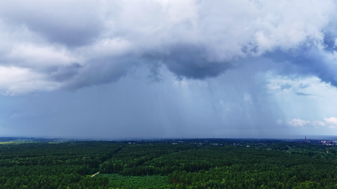 Grey clouds and incoming weather front cover landscape in moody late afternoon lighting, aerial establishing tracking right