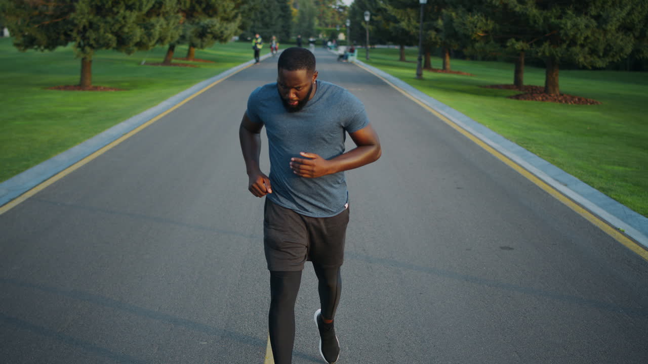 Jogger che inizia a correre nel parco. Sportivo concentrato che fa jogging all'aperto.
