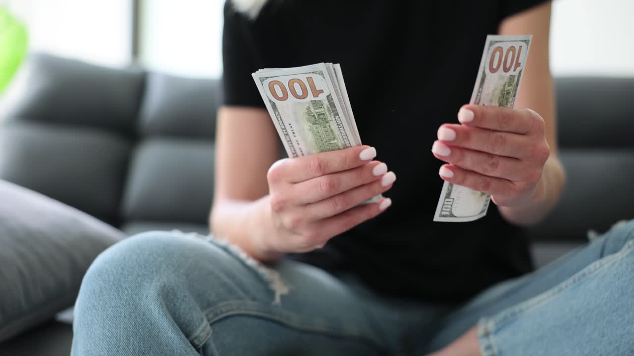 Person Counting Hundred Dollar Bills