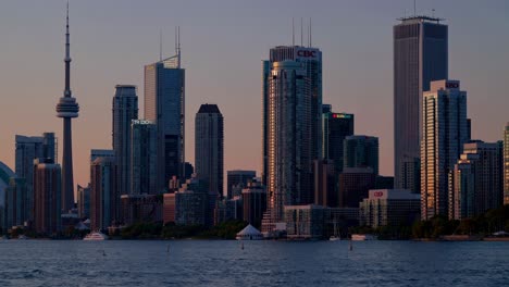 serene urban skyline reflecting on calm waters during sunset. prominent skyscrapers and communication tower dominating metropolitan landscape with golden light illuminating architectural silhouettes