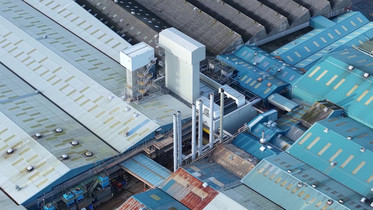 稼働中の冷却ファンと換気設備を備えた一般的な工業団地の工場屋根のドローン空撮。