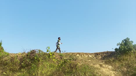 static slow motion of asian man jogging against sunny blue sky