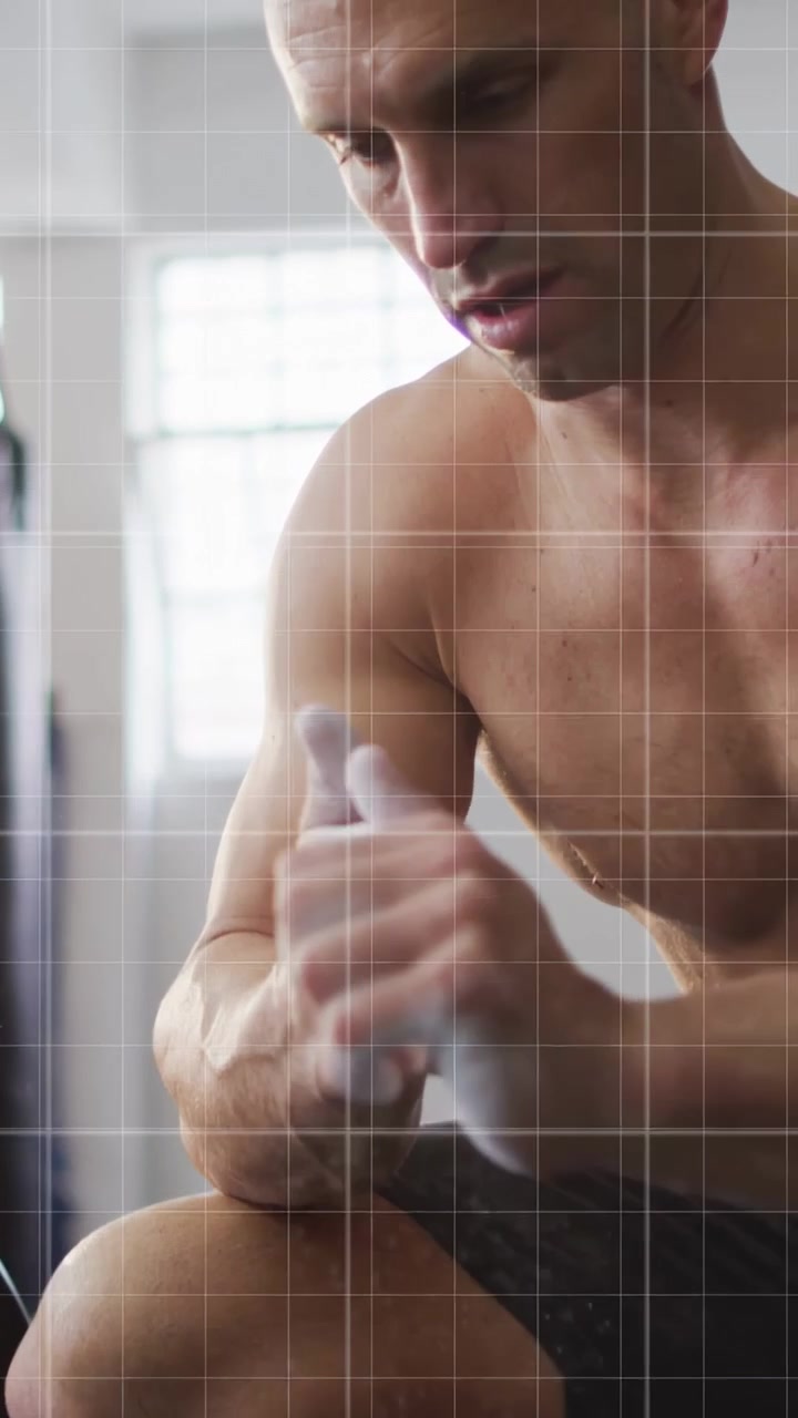 Vertical video: Man rubbing chalk, reaching for bar, preparing strength pull while red grid moving