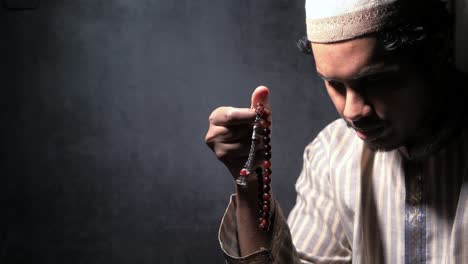 muslim man praying with rosary