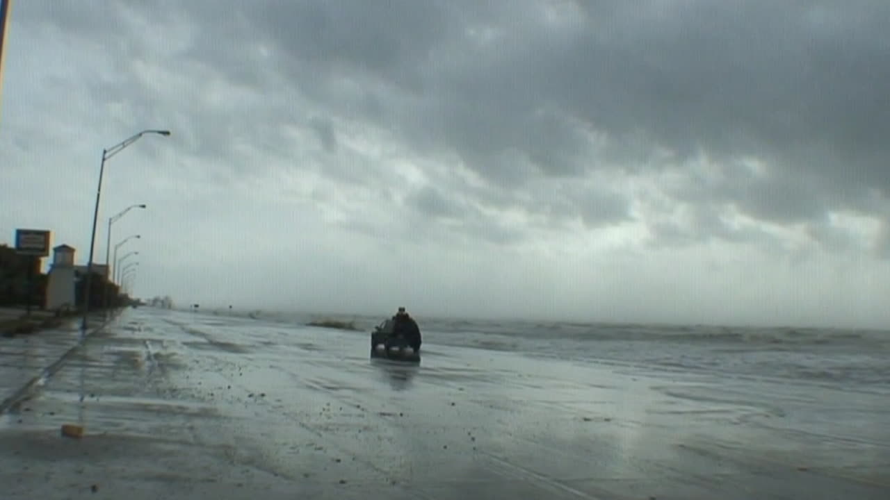 자동차가 지나갈 때 거대한 허리케인이나 폭풍이 몰아치는 동안 거대한 파도가 갤버스턴 텍사스에서 방파제를 두드립니다.