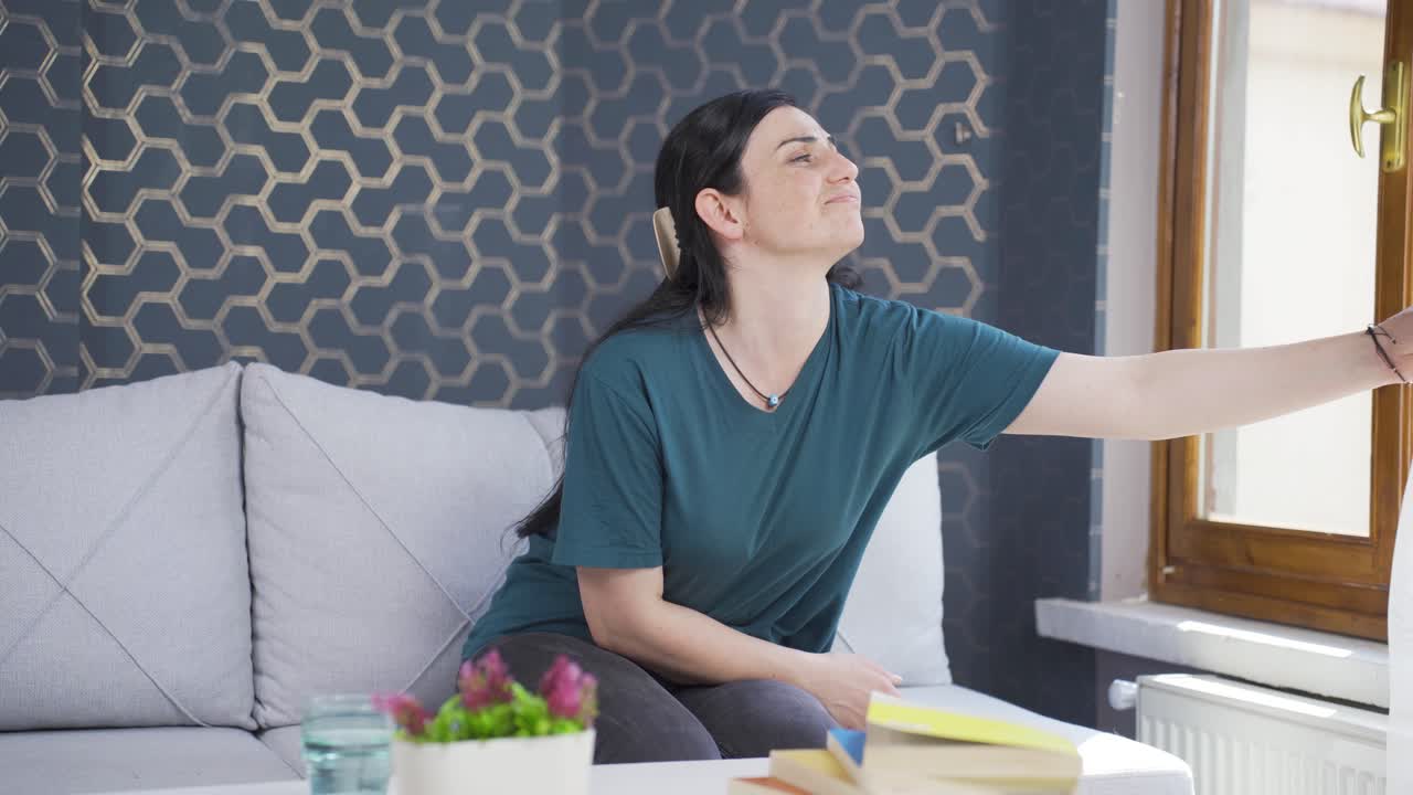 집의 커튼을 닫는 여자.