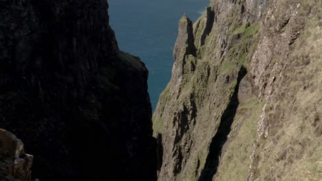 Aerial-tilt-down-shot-of-gigantic-Beinisvord-Cliff-on-Suduroy-Island-during-sunny-day