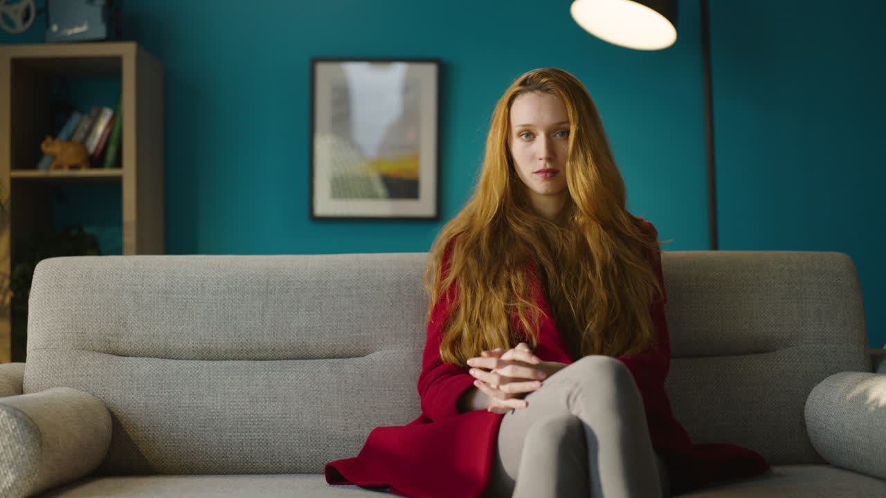 회색 벨 소파 에 앉아 있는 여자