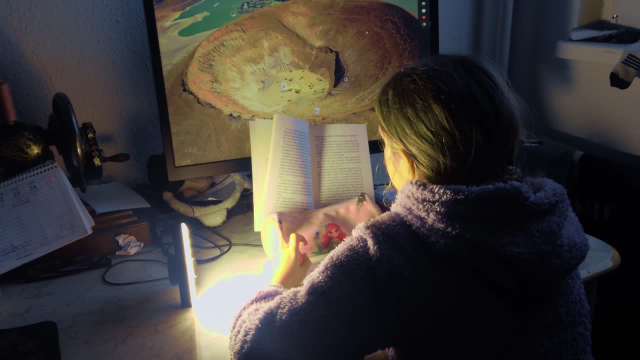 A cinematic wide shot of a tired student studying at a dark desk. Warm lamp light highlights the quiet fatigue of nocturnal education and the mental effort of late-night homework in sharp 4K b-roll