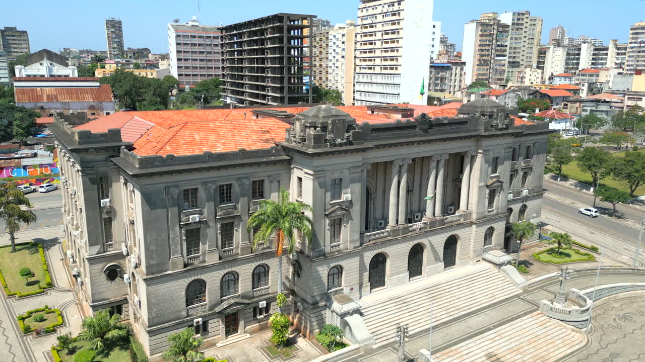 모잠비크의 마푸토에 있는 마푸토 시청의 외관과 그 배경에는 고층 건물들이 있습니다.