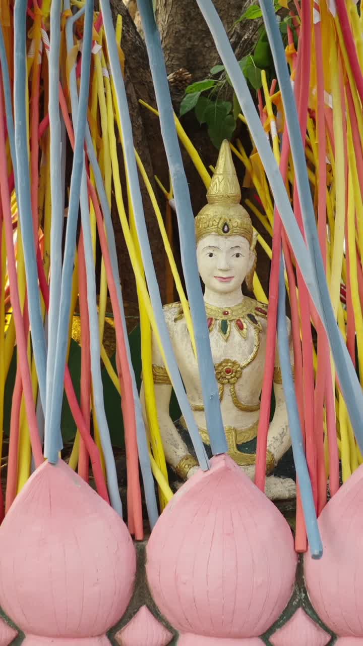 Statua buddista con nastri colorati