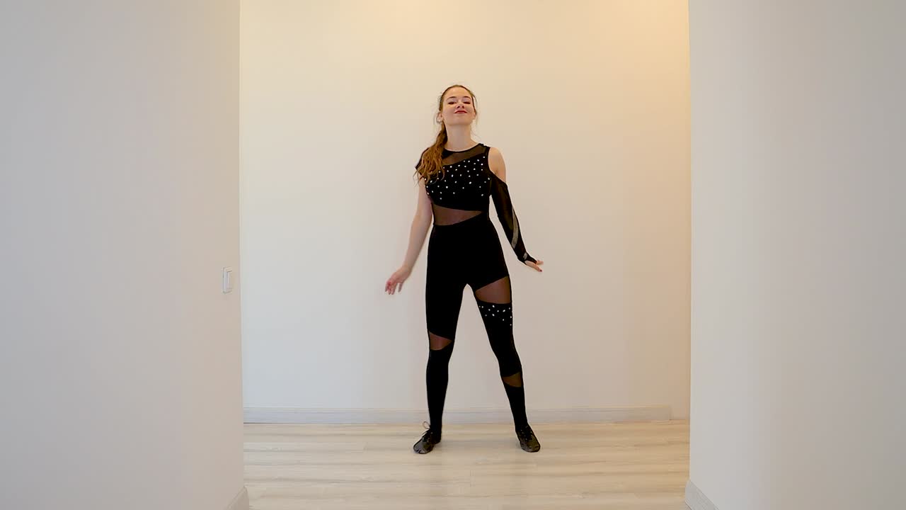 Slow motion clip of an attractive and energetic young Caucasian female dancer performing a dance inside home in front of a white background