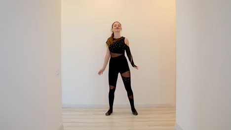 slow motion clip of an attractive and energetic young caucasian female dancer performing a dance inside home in front of a white background