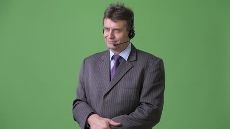 mature handsome businessman against green background