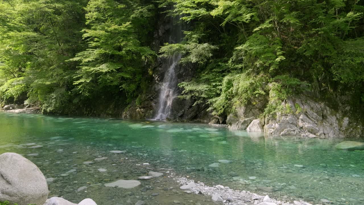 Stunning panoramic view out over lush green valley with waterfall