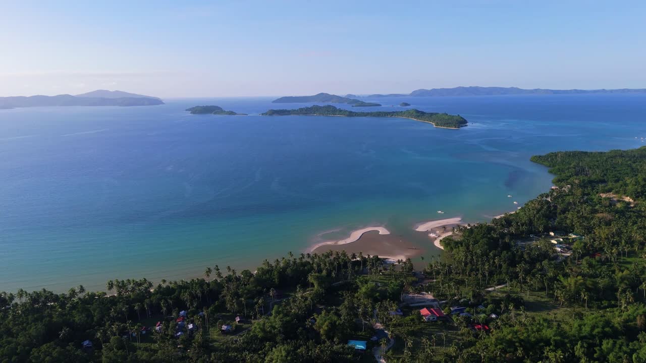 Cinematic drone shot of the pristine White Beach in Port Barton, Palawan, with Inaladelan Island (German Island) visible on the horizon. Tropical paradise in the Philippines