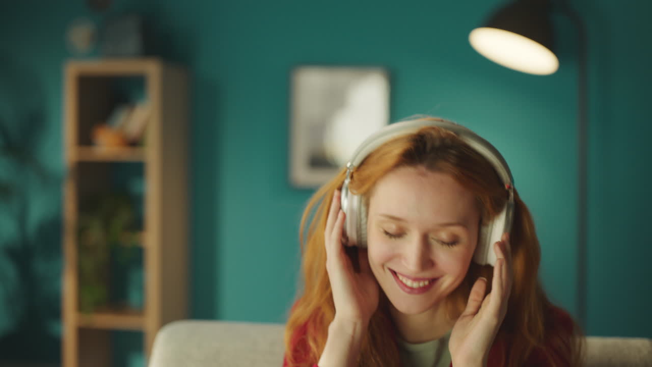 헤드폰을 들고 음악에 맞춰 춤을 추는 여자