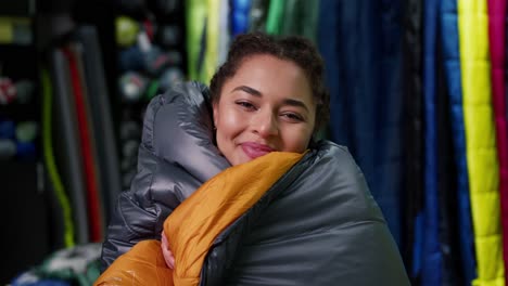 Portrait-of-a-woman-covered-in-sleeping-bag-at-tourist-store