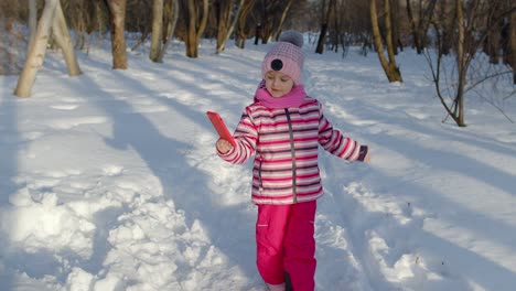 Child-girl-vlogger-making-selfies-photo-for-social-networks,-chatting-with-friends-in-winter-park