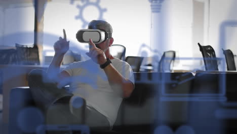 multiple digital icons floating against caucasian senior businessman wearing vr headset at office