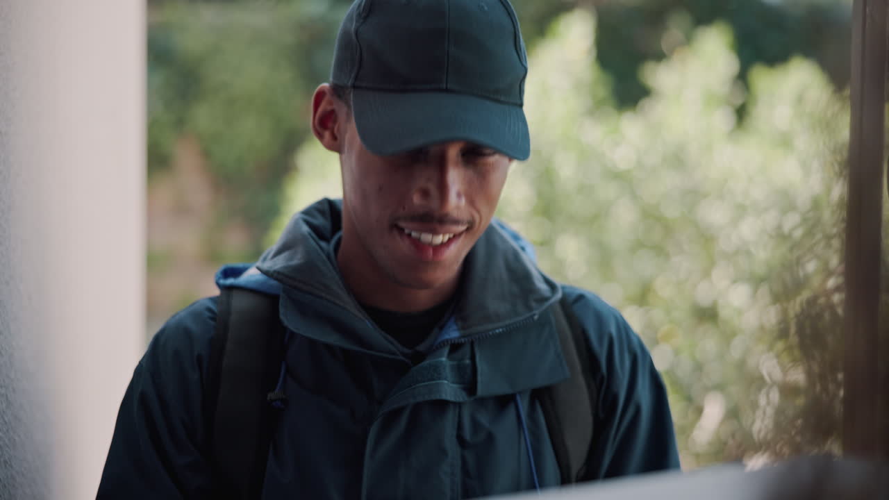 집 밖 에서 패키지 를 들고 있는 배달자 가 미소 짓고 있다