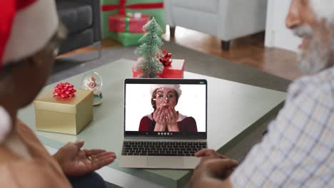 feliz pareja afroamericana senior en videollamada con una amiga en tiempo de navidad
