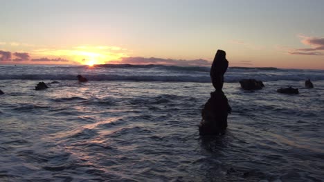 impresionantes vistas de la puesta de sol con la marea baja en la playa laguna mientras el sol se asoma entre las rocas y se refleja en el agua