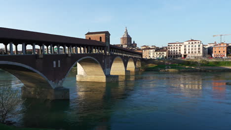 skyline of ponte coperto bridge is over the ticino river and pavia cathedral background