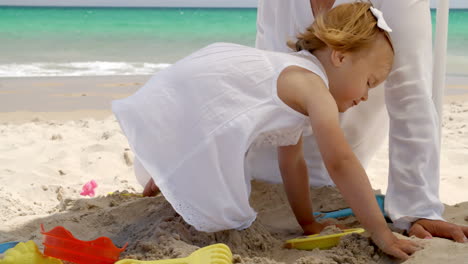 leuk jong meisje dat in het zand speelt.