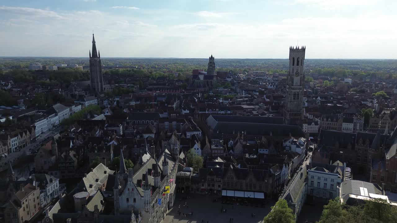Rivelazione epica con drone che parte dai canali storici per un panorama mozzafiato di Bruges. Con la torre del Belfry, chiese gotiche e tetti medievali nelle Fiandre, Belgio.