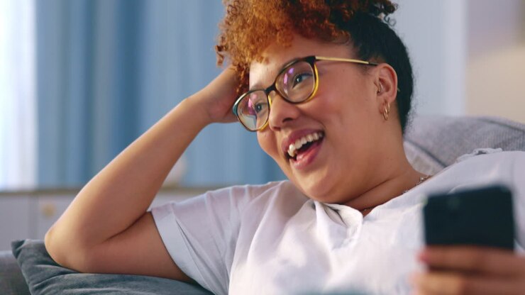 Donna nera, telefono e che pensa a un meme divertente
