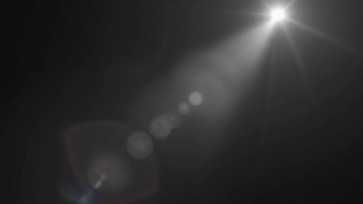 Bagliore di luce bianca brillante che si muove su sfondo scuro