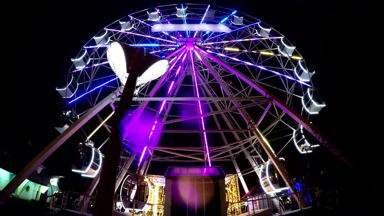 rueda gigante vacía atracción mágica girando por la noche iluminado timelapse led
