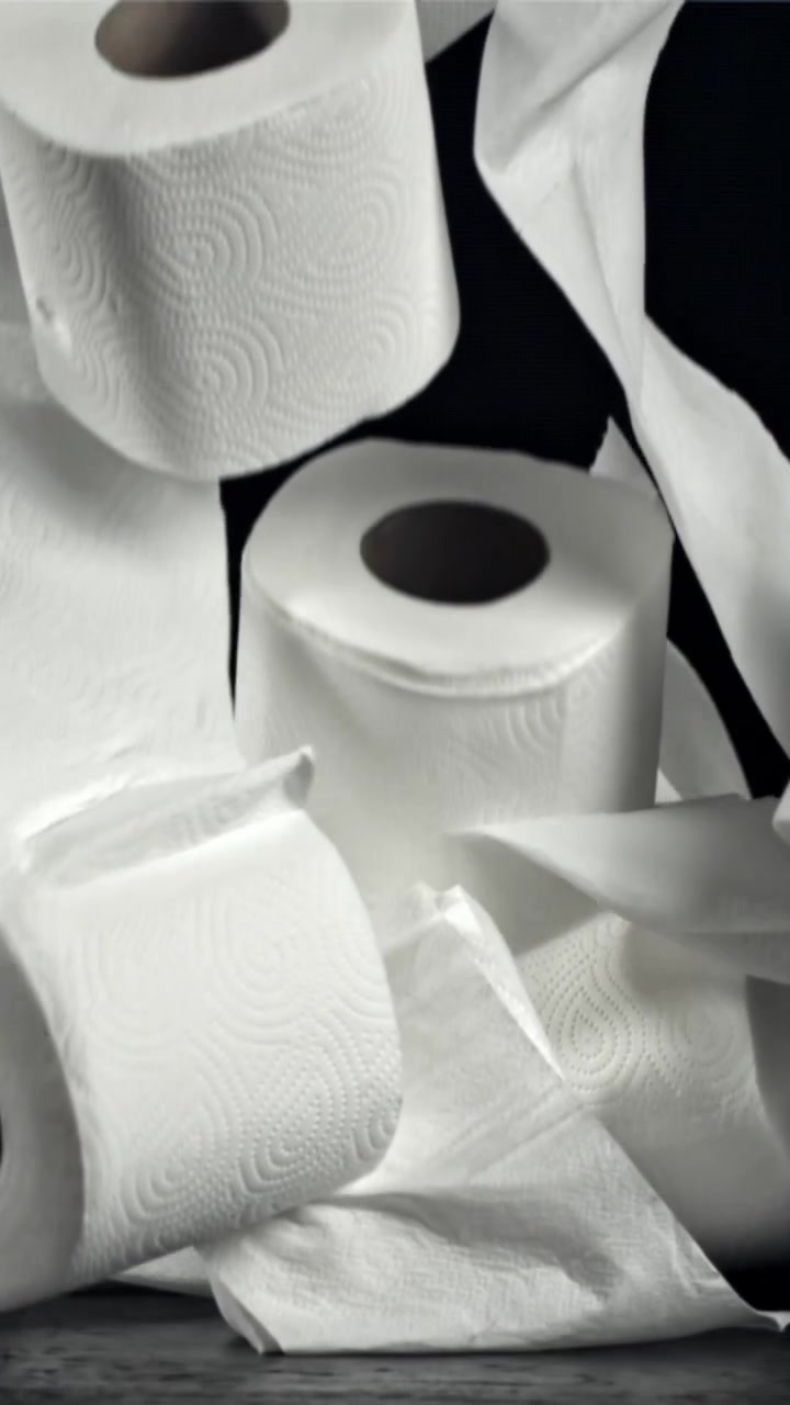 Multiple Rolls of White Toilet Paper Falling in Slow Motion