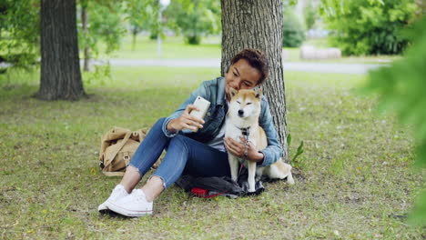woman taking a selfie with her dog in a park
