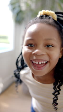 vertical video portrait of happy african american girl with braided hair smiling, slow motion