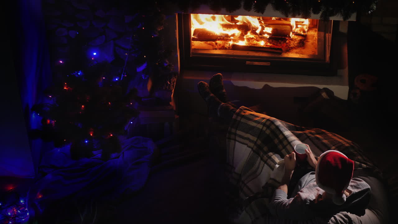 un hombre admira el fuego en la chimenea junto a las decoraciones navideñas