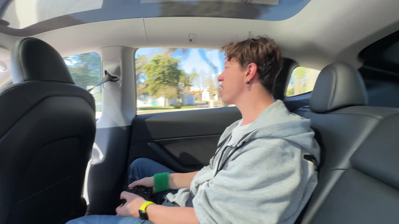 Person sitting in the backseat of a Tesla car
