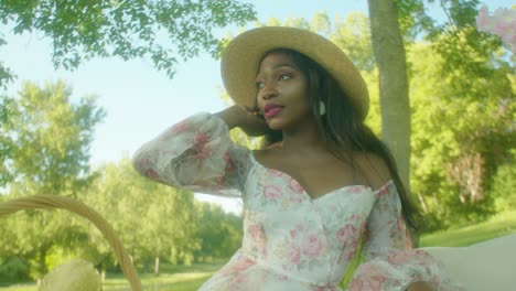 black woman adjusting hair on picnic in park close up