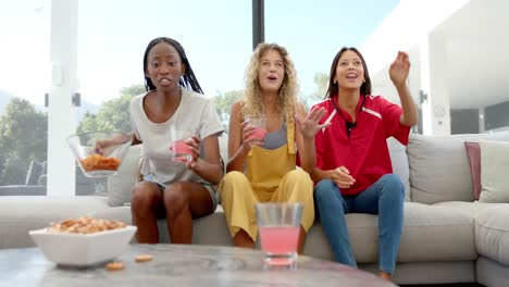 Aufgeregt-Verschiedene-Freundinnen-Mit-Chips-Und-Getränken,-Die-Sport-Im-Fernsehen-Schauen,-Zeitlupe