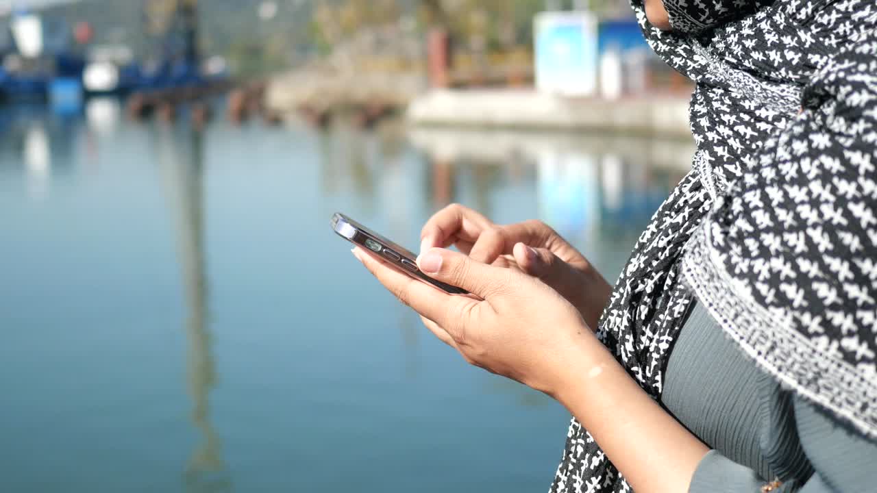 항구 근처 에서 휴대 전화 를 사용하는 여자