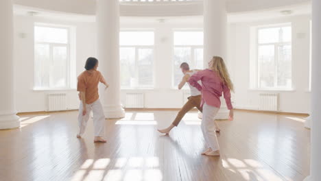 multiethnic group of contemporary dancers dancing and moving around the studio 1