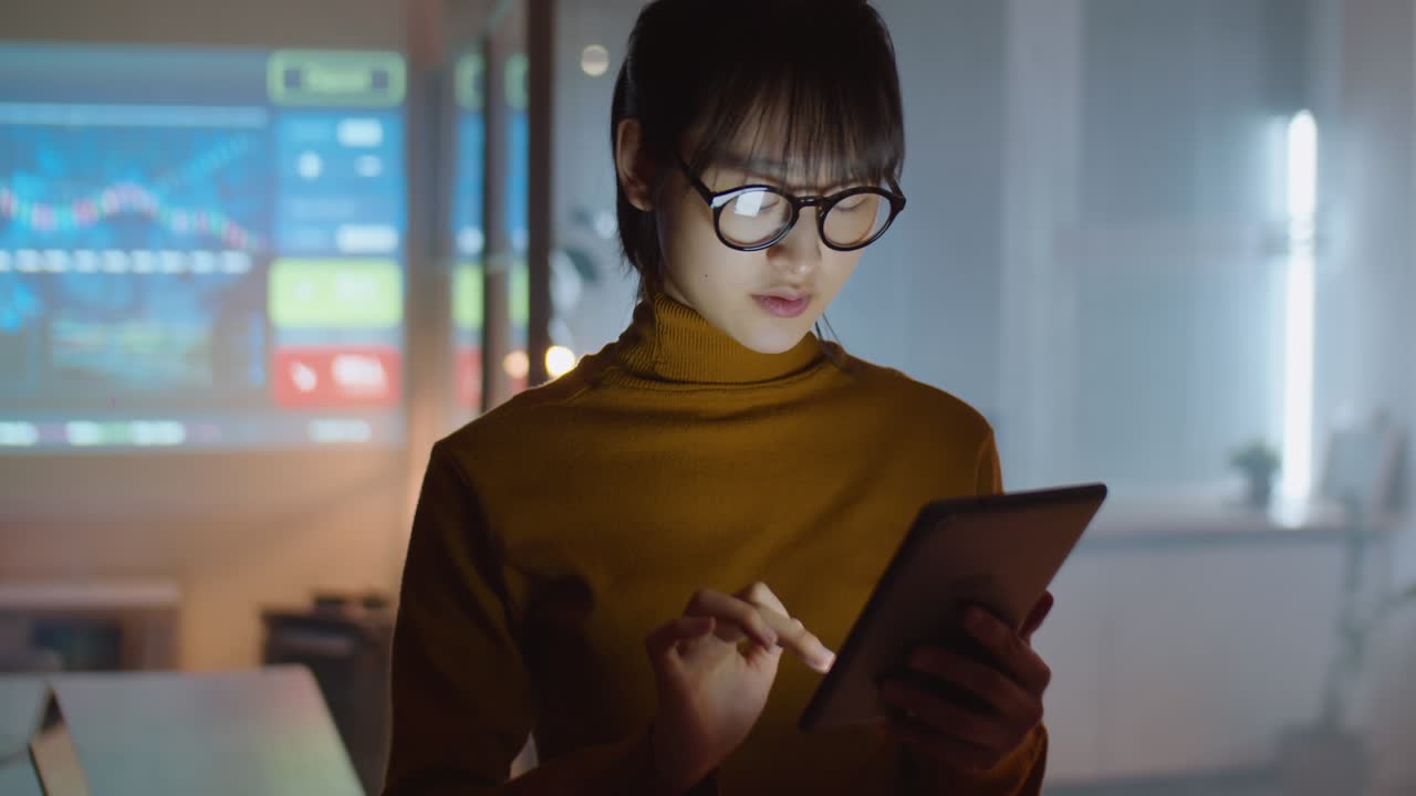 Asian Woman Using Digital Tablet in Office at Night