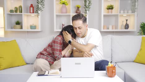 una pareja casada viendo una película de terror en su computadora portátil en casa.